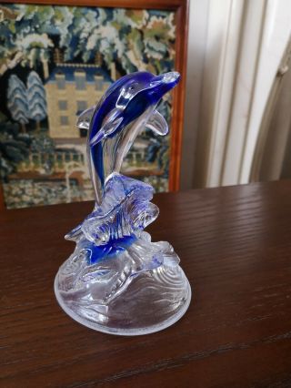 A Clear And Blue Glass Orniment Of A Dolphin