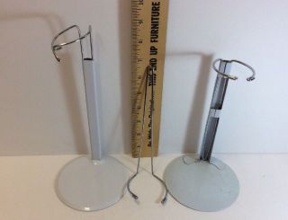 TWO WHITE METAL ADJUSTABLE DOLL STANDS AND ONE EXTRA WIRE INSERT 2